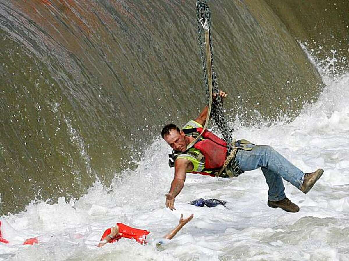 In this Tuesday, June 30, 2009 file photo, a construction worker, suspended from a crane, rescues a woman who fell into the Des Moines River near the Center Street Dam in downtown Des Moines, Iowa. This image by Register photographer Mary Chind won the 2010 Pulitzer Prize for Breaking News Photography as announced in New York, Monday, April 12, 2010. (AP Photo/The Des Moines Register, Mary Chind) NO SALES, MAGS OUT, MANDATORY CREDIT