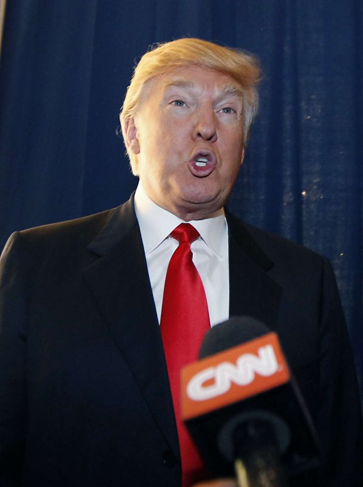 FILE - A Thursday, Feb. 2, 2012 photo from files showing Donald Trump talking to reporters prior to a news conference in Las Vegas with Republican presidential candidate, former Massachusetts Gov. Mitt Romney. Donald Trump has launched a blistering attack on Scotland's First Minister Alex Salmond over plans to build a wind farm off the coast of his luxury Scottish golf resort. In an open letter, the New York real estate tycoon calls the wind farm "horrendous" and says Salmond is "hell bent on destroying Scotland's coast line and therefore Scotland itself." Niall Stuart, chief executive of Scottish Renewables, which represents the wind farm industry, reacted with anger Friday, Feb. 10, 2012 to Trump's intervention, asking "Who is Donald Trump to tell Scotland what is good for our economy or environment?" (AP Photo/Gerald Herbert, File)