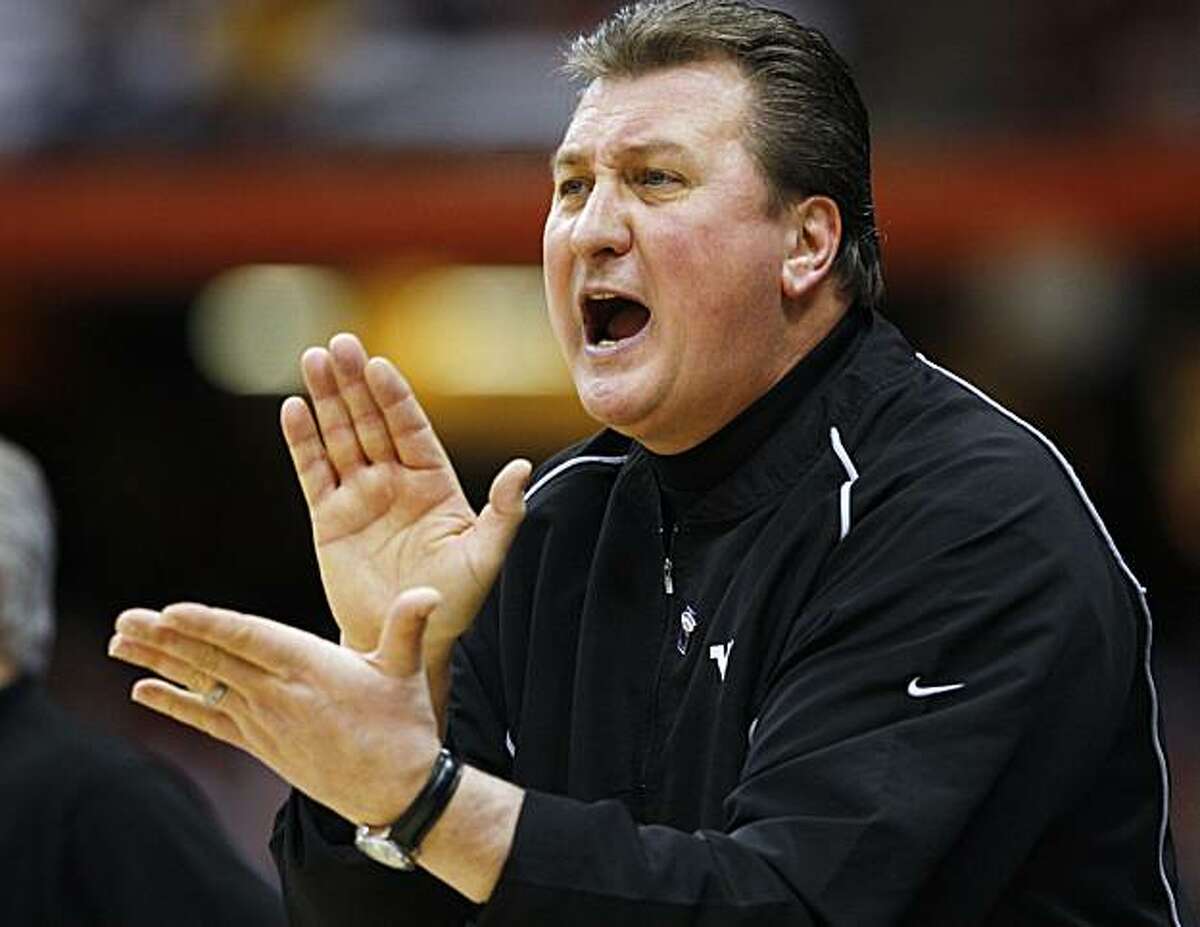 West Virginia coach Bobby Huggins calls out to his team during the first half of a semifinal in the East Regional of the NCAA college basketball tournament against Washington on Thursday, March 25, 2010, in Syracuse, N.Y.