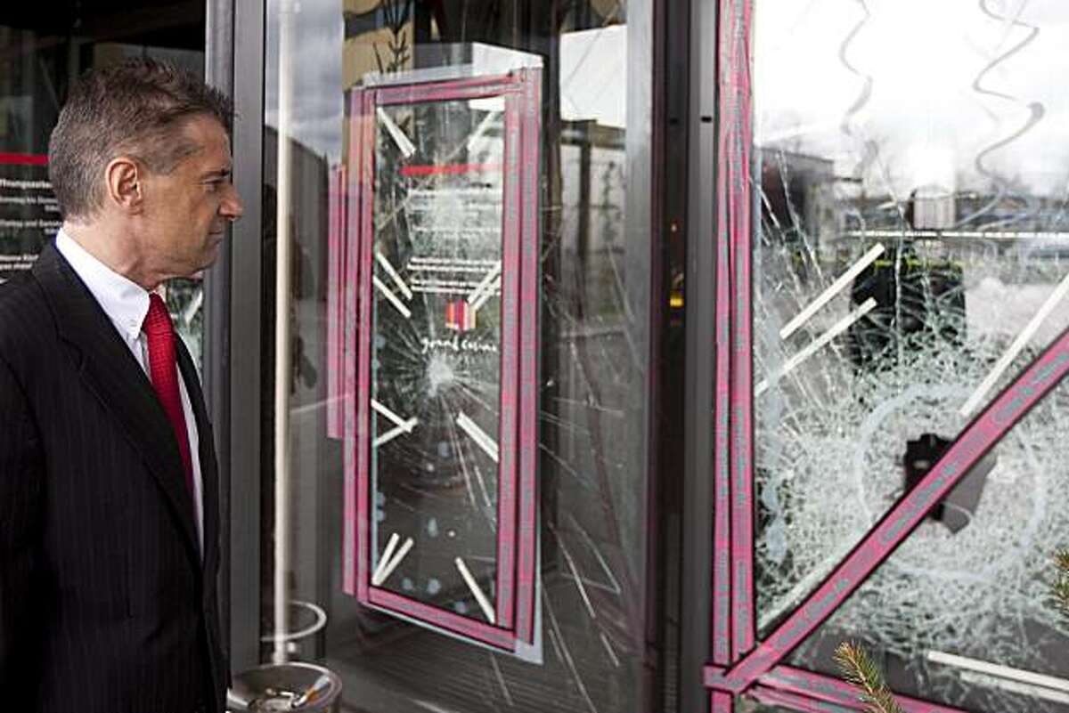 Casino managing director Michael Favrod stands in front of the smashed front door of the Grand Casino in Basel, on March 28, 2010. An armed gang of about ten masked men raided the casino packed with about 600 guests early Sunday and made off with hundredsof thousands of US dollars, according to Swiss prosecutors. One smashed the front door with a sledgehammer, and the others ran inside with machine guns and pistols, the statement said.