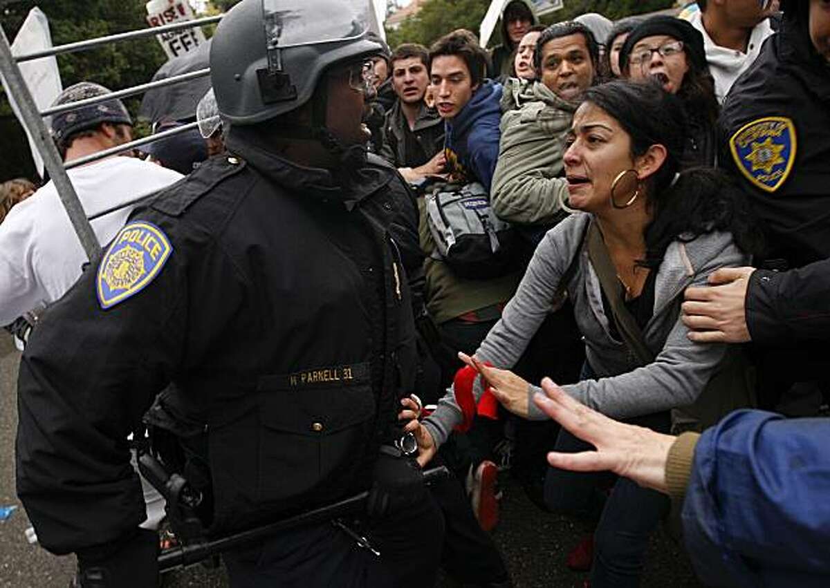 As students rally on the UC Berkeley campus in protest of pay cuts and layoffs, UC Ploice push back protesters as they move in barricades in front of Wheeler Hall in Berkeley, Calif. on Friday November 20, 2009.