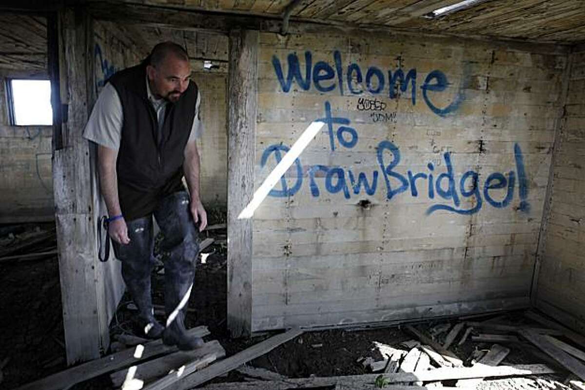 Eric Mruz, manager of the Don Edwards San Francisco Bay National Wildlife Refuge investigates a dilapidated building in historic Drawbridge, an abandoned fishing and hunting community located on the Don Edwards San Francisco Bay National Wildlife Refuge near San Jose, are being naturally reclaimed by the south bay salt flats on Tuesday March 23, 2010 in Drawbridge, Calif.