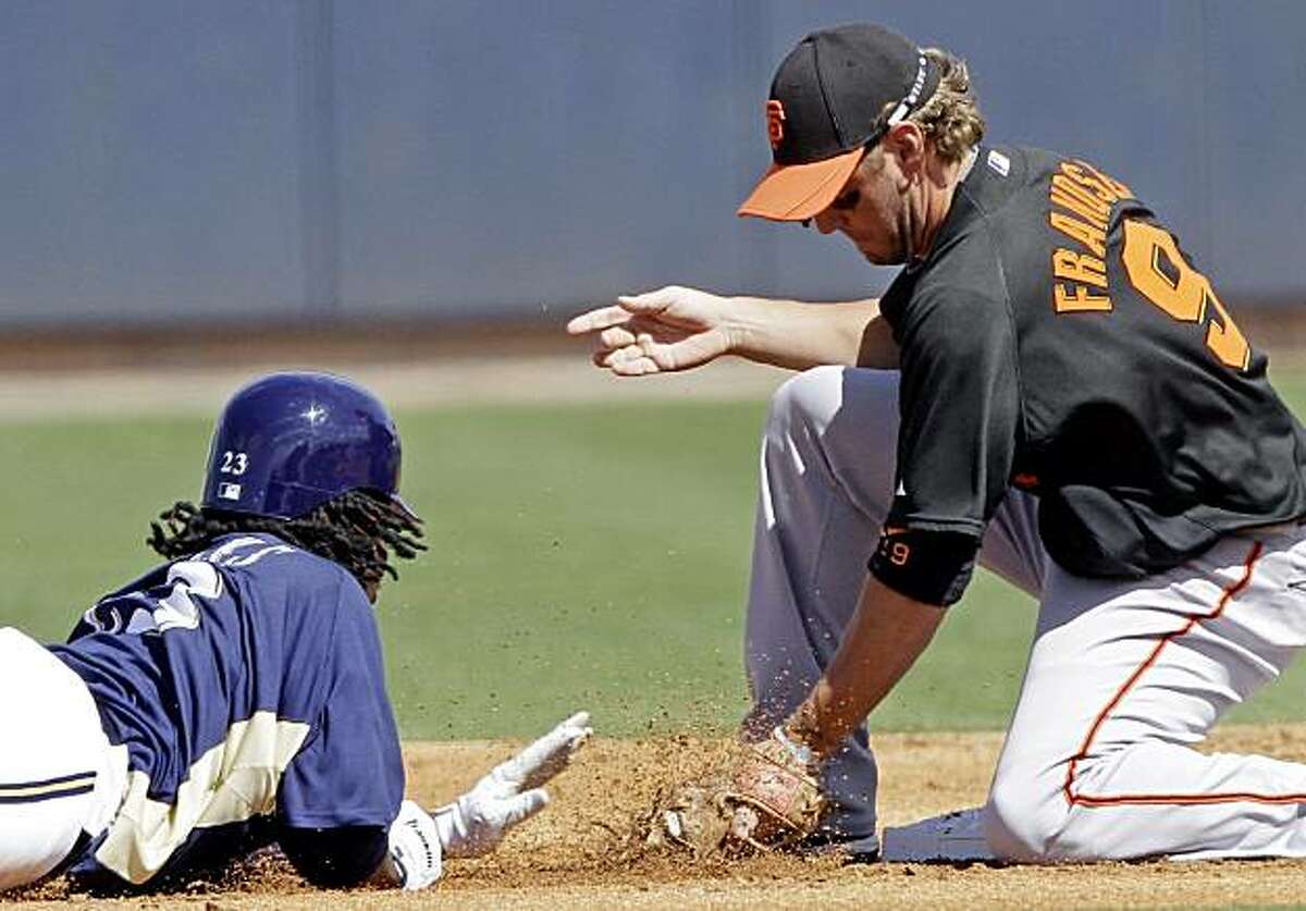 San Francisco Giants second baseman Kevin Frandsen picks off Milwaukee Brewers' Rickie Weeks at second base during the first inning of a spring training baseball game Saturday, March 6, 2010, in Phoenix.