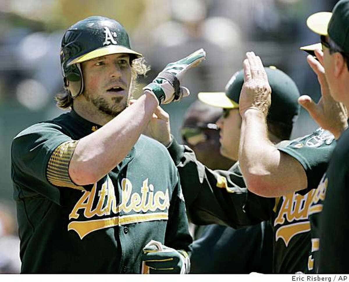 Oakland Athletics' Travis Buck is greeted by his teammates in the dugout after hitting a home run off Detroit Tigers starting pitcher Nate Robertson during the sixth inning of a baseball game in Oakland, Calif., Wednesday, June 4, 2008. Oakland won 10-2, to sweep the three-game series. (AP Photo/Eric Risberg)