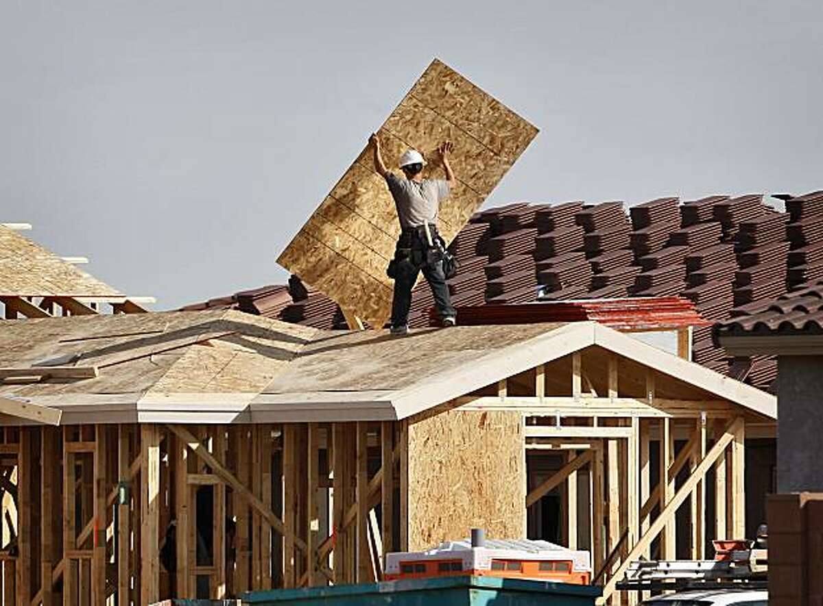 In this photo made Feb. 4, 2010, a new home is under construction in Gilbert, Ariz. Construction of new homes and apartments posts better-than-expected January rebound.