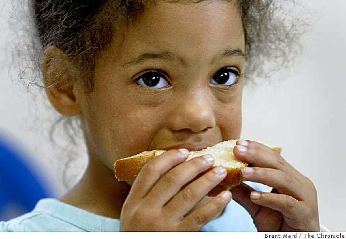 Meiko Jackson enjoys her cheese sandwich during snack time at the Oakland home of Kathy Sapp, who cares for seven children there. All of her daycare clients are payed for with California state funds, and since the budget has not passed she has not received a check in over two months.