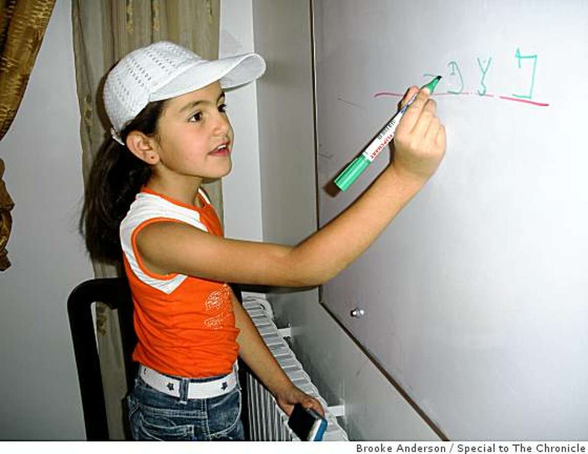 Marian Shanees, a student at the Aramaic Language Institute, does an exercise on the board during class.