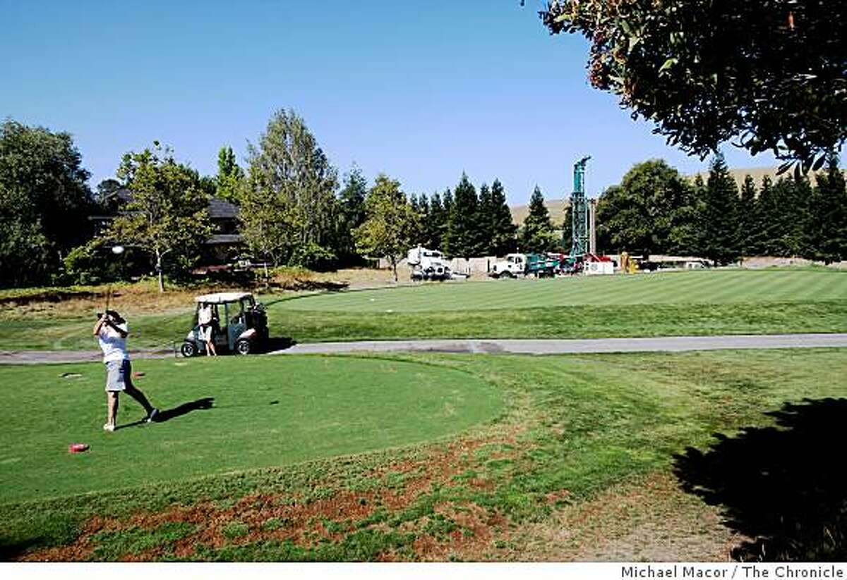 Golfers at Blackhawk Country Club in Danville, Calif., Wednesday July 23, 2008, have a little to contend with as a water well drilling rig digs close to the tee box. Drilling for water currently down to depth of 600 feet with plans on going to 1,000 feet in search for a strong water supply.
