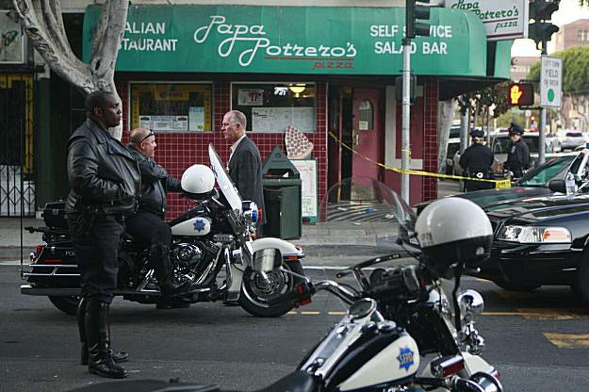 Officials work on 24th Street at Portrero Avenue outside of Papa Potrero's Pizza, the scene of a multiple shooting in San Francisco, Calif. on Sunday, September 20, 2009.