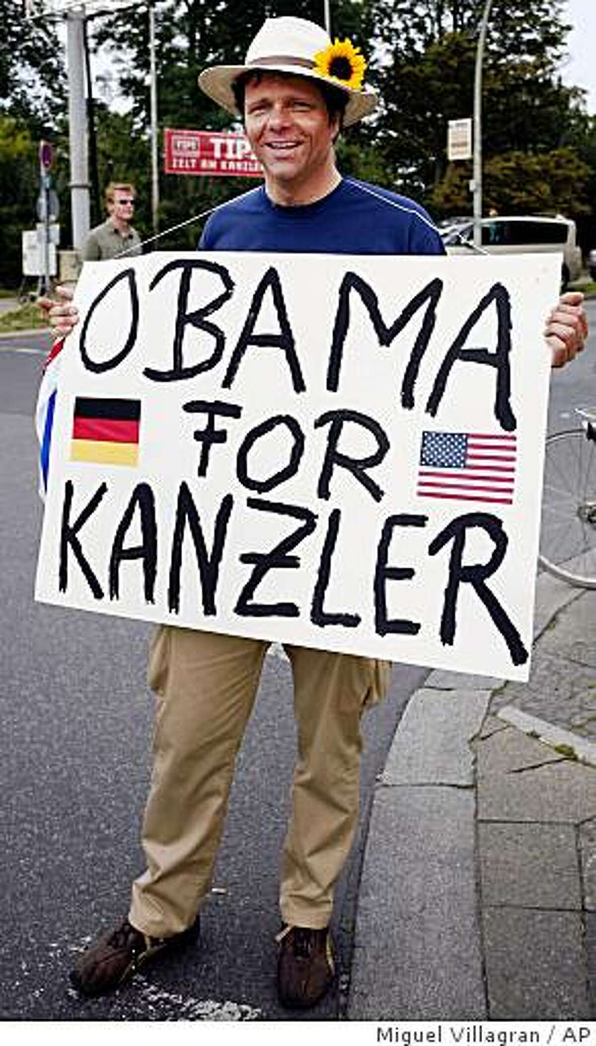 A supporter of U.S. Democratic presidential candidate Sen. Barack Obama, D-Ill., holds a poster meaning "Obama for Chancellor" prior to Obama's speech at the victory column in Berlin Thursday, July 24, 2008. (AP Photo/Miguel Villagran)