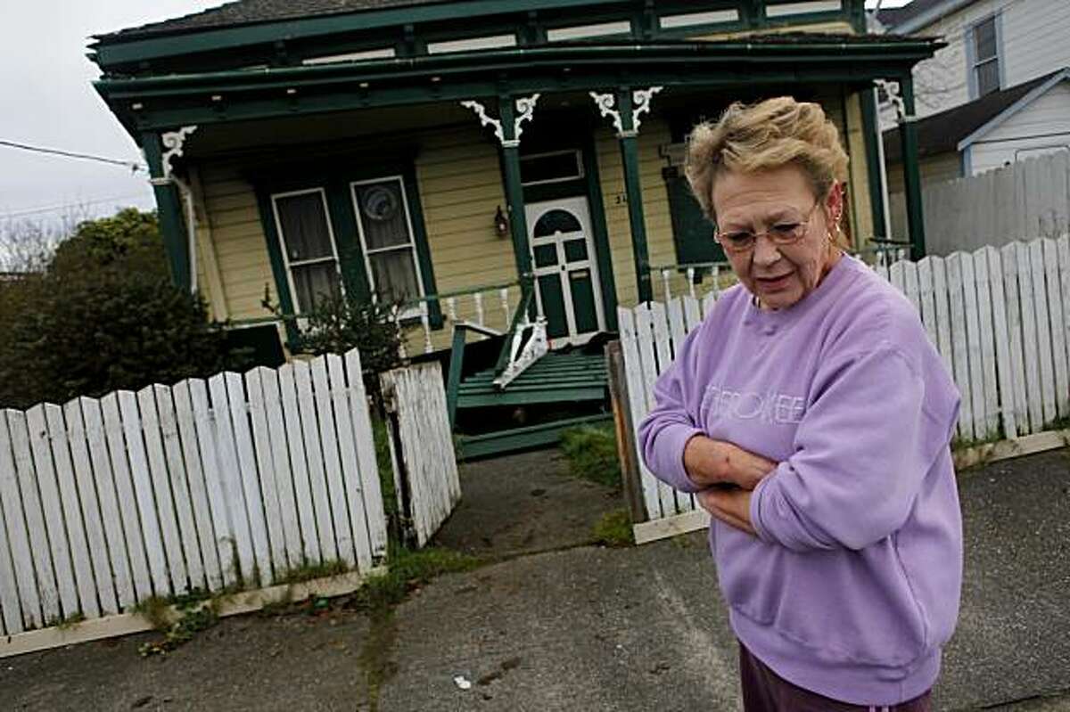 Connie Beattie looks over the damage of a house on California Street in Eureka on Sunday. The home collapsed off of its foundation during Saturday's 6.5 earthquake.