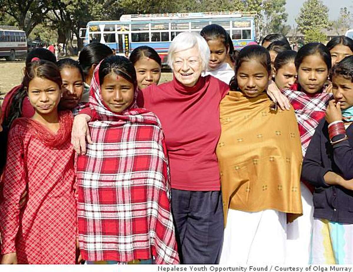 Olga Murray 83 is largely responsible for eradicating female child slavery in a small part of western Nepal by offering families a pig to raise instead of selling their daughters. She is shown here with some of the young women she saved and was later able to get into schools.