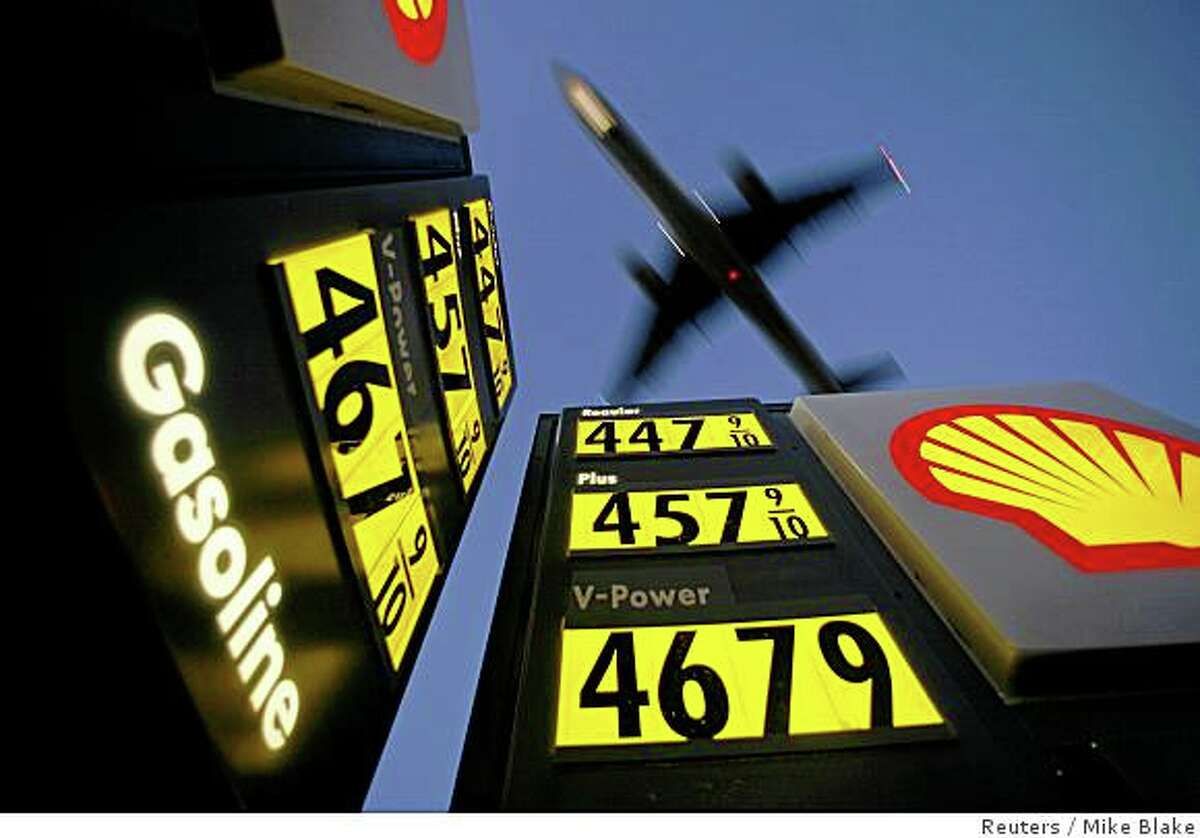 Gasoline prices are advertised at a gas station near Lindbergh Field as a plane approaches to land in San Diego, California in this June 1, 2008 file photo. To match Reuters Witness story OIL/TAXI in which, Daniel Fineren, who is a senior energy correspondent, describes his recent encounter with a Spanish taxi driver on the way home from the World Petroleum Congress. To match Reuters Witness story OIL/TAXI. REUTERS/Mike Blake (UNITED STATES)