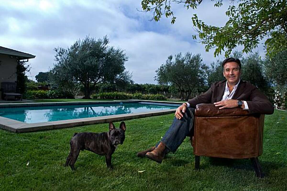 Michael Polenske, founder of Blackbird Winery with his dog Oliver pool side at his home in Napa, California on Oct. 9, 2009.