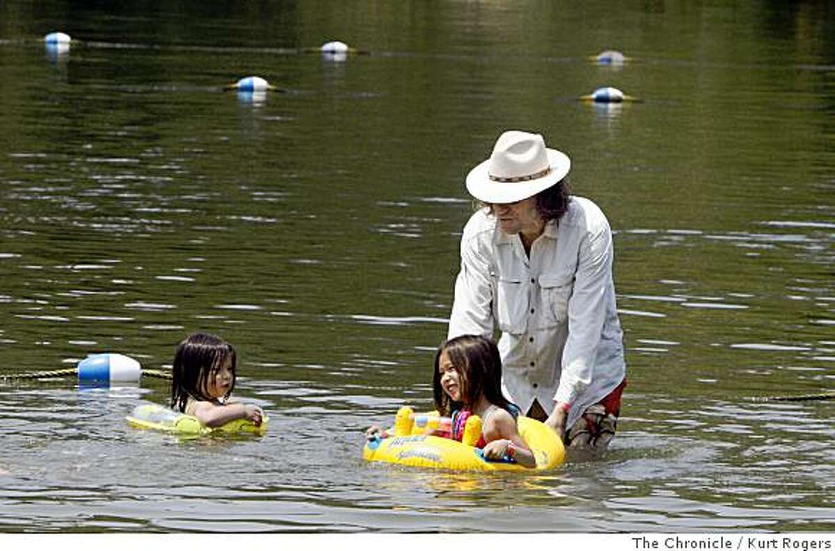 Jengiz Haas splashes around in the water at Lake Temescal with his kids Madison and Poinciana he likes to where a shirt and hat for full protection from the sun. on Wednesday, July 09 2008 in Oakland , Calif Photo by Kurt Rogers / The Chronicle.
