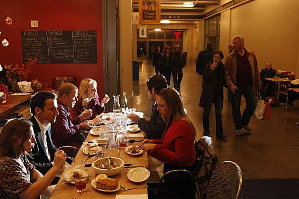 Diners, who all agreed that they don't mind eating in a hallway near the bathroom and the building exit as long as the food is good and they are with friends, enjoy an evening dinner II Cane Rosso in the Ferry Plaza on Friday, Dec. 18, 2009 in San Francisco, Calif.