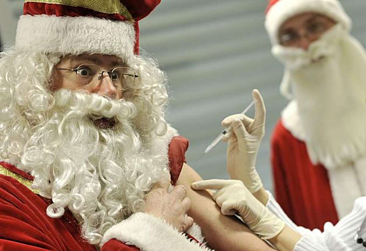 A man dressed as Santa Claus receives his H1N1 flu vaccine during a dress rehearsal before his weekend performance in Budapest, Hungary, Thursday, Dec. 3, 2009. The H1N1 flu has officially reached epidemic proportions in Hungary with 16 people reported to have died from the virus and some 300 others hospitalized. The Hungarian government has issued recommendations for every Santa Claus to get vaccinated before they distribute presents to children at Christmas, or attend other meetings with children. (AP Photo/Bela Szandelszky)