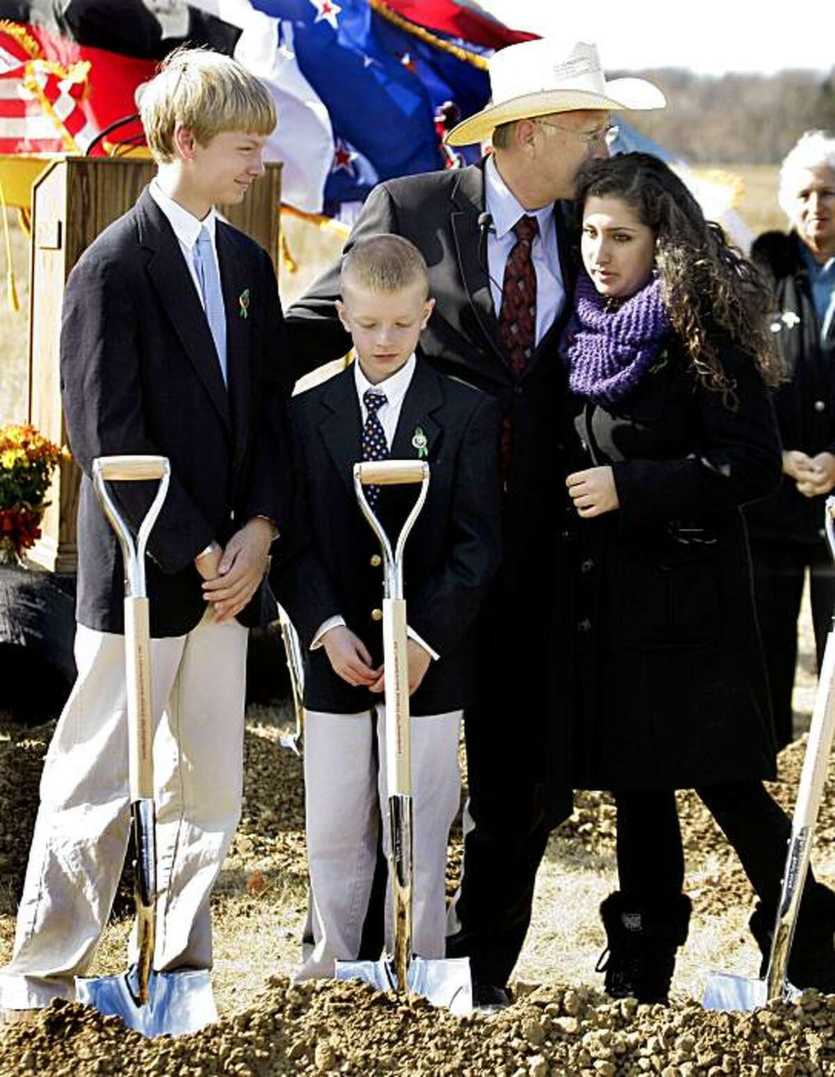 Secretary of the Interior Ken Salazar, rear, embraces Sarah Wainio, sister of Flight 93 passenger Honor Elizabeth Wainio, right, with Campbell Peterson, left, and Peyton Peterson, grandsons of Flight 93 passengers Donald Peterson and Jean Hoadley Peterson, after taking part in the ground breaking for the Flight 93 National Memorial Saturday, Nov. 7, 2009 in Shanksville, Pa.. Plans are to dedicate the memorial on Sept. 11, 2011. (AP Photo/Gene J. Puskar)