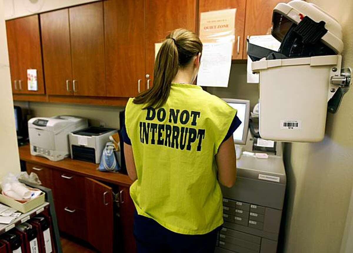 Eleni Drury, a registered nurse in the labor and delivery ward at Saint Rose Hospital, wears a yellow vest to minimize disruptions while dispensing medications in Hayward, Calif., on Tuesday, Oct. 27, 2009.