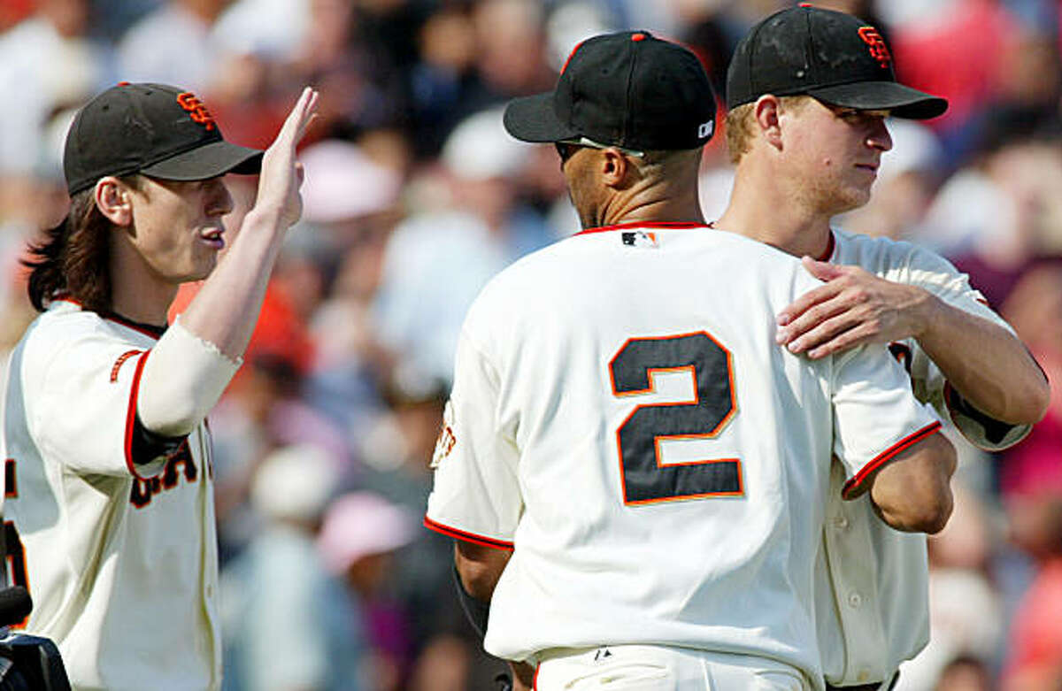San Francisco Giants pitcher Matt Cain, right, and Randy Winn (2) celebrate as Giants' Tim Lincecum waits for a high five after a baseball game against the Chicago Cubs, Sunday, Sept. 27, 2009 in San Francisco. The Giants beat the Cubs 5-1. (AP Photo/George Nikitin)
