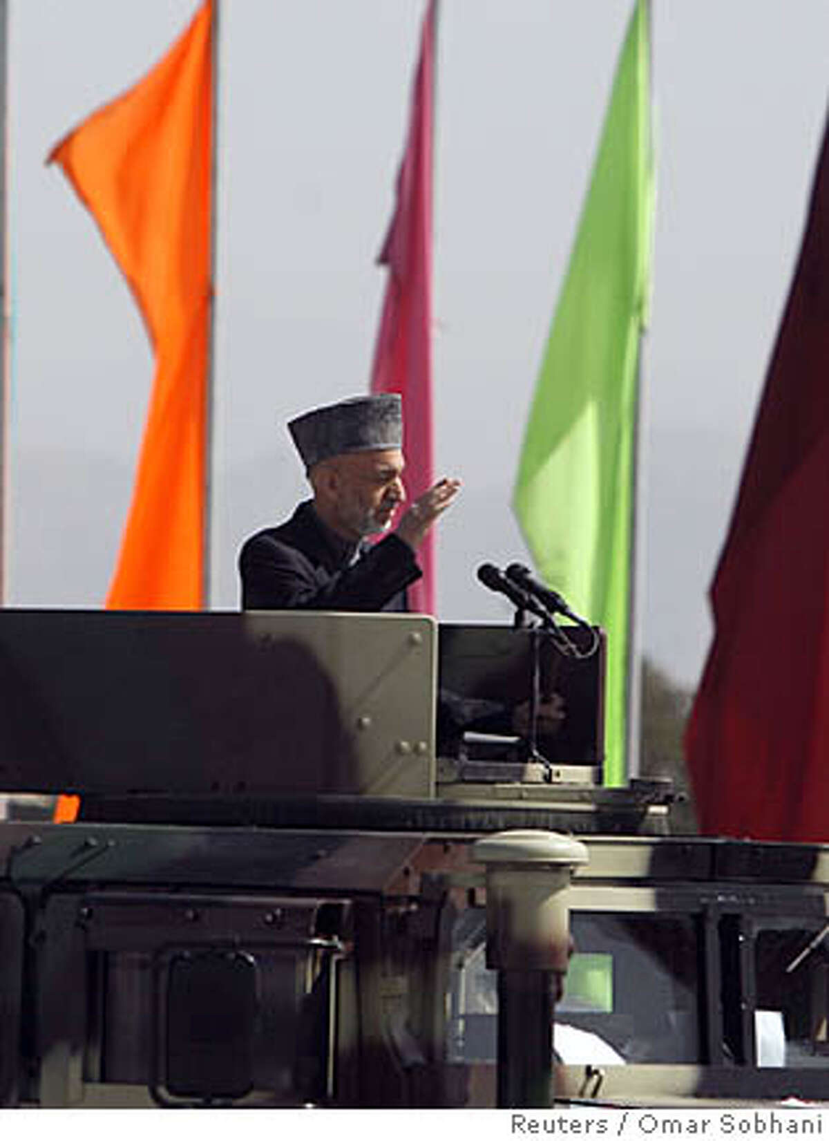 Afghan President Hamid Karzai salutes moments before an assassination attempt during a celebration in Kabul April 27,2008. Karzai escaped unhurt after an assassination attempt by Taliban fighters with guns and rockets during an official celebration in the capital, Kabul, on Sunday. REUTERS/Omar Sobhani (AFGHANISTAN)