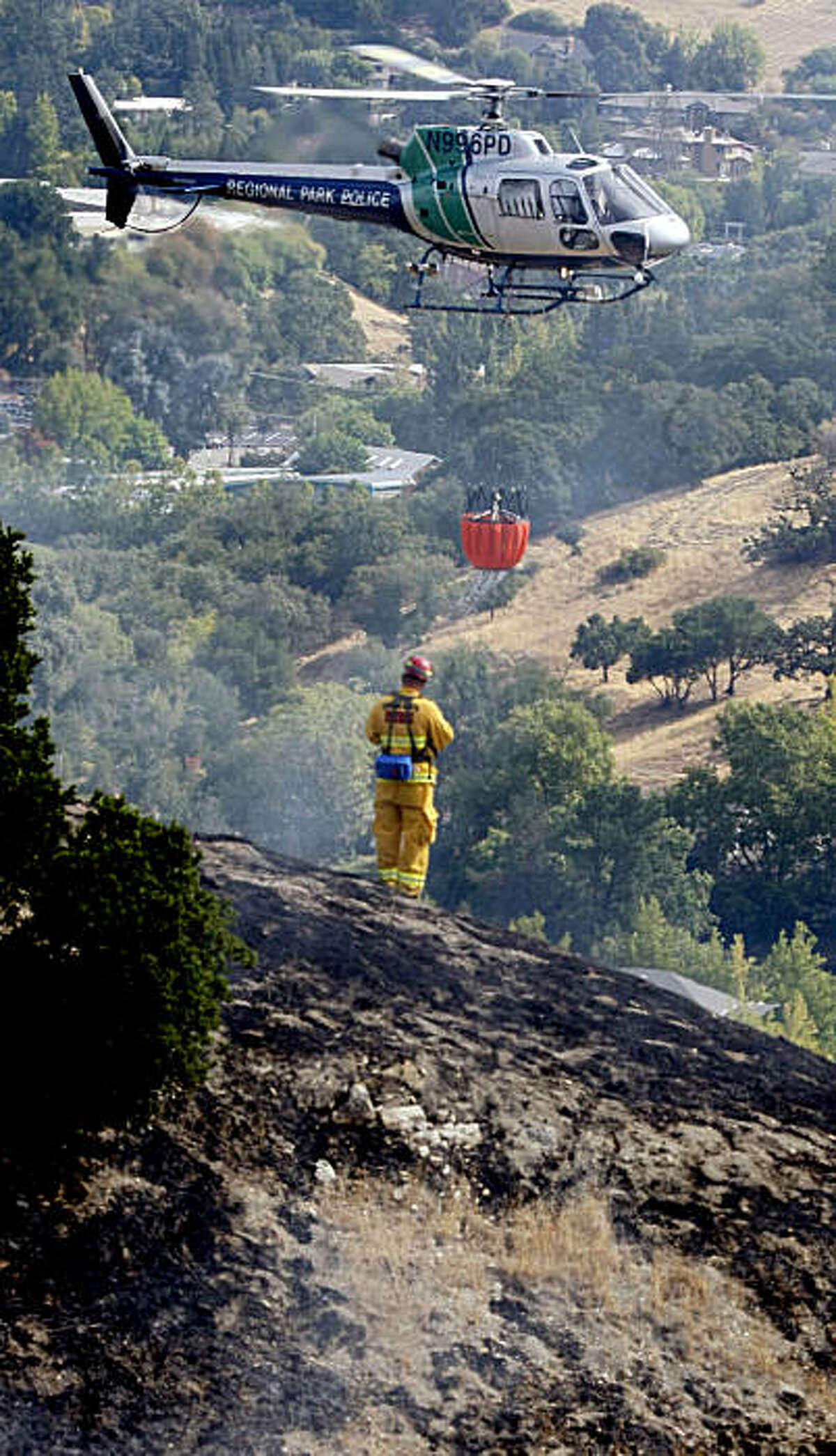 Smoke covers most of the Valley south of Walnut Creek as Capt. Chris Gonsalves from Contra Costa Fire directs a Cal-Fire helicopter to his target zone on a fast moving brush fire above Ross in Walnut Creek Wednesday Sept 2, 2009.
