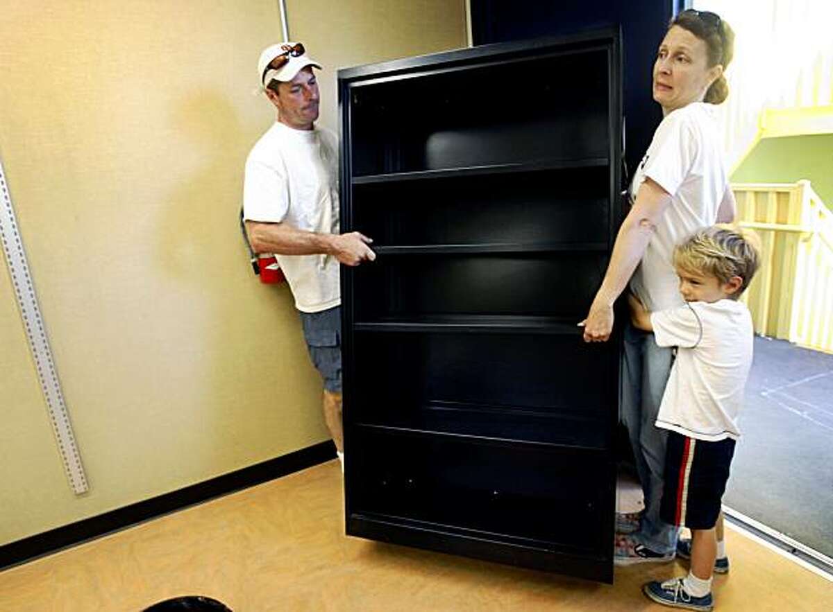 Steven Enfield (left) moves a bookcase with his wife Diana Bowen and their son Henry, an incoming Kindergartner, at Daniel Webster Elementary School in San Francisco, Calif., on Saturday, Aug. 15, 2009 where parents and other volunteers cleaned up and painted classrooms for the new school year.