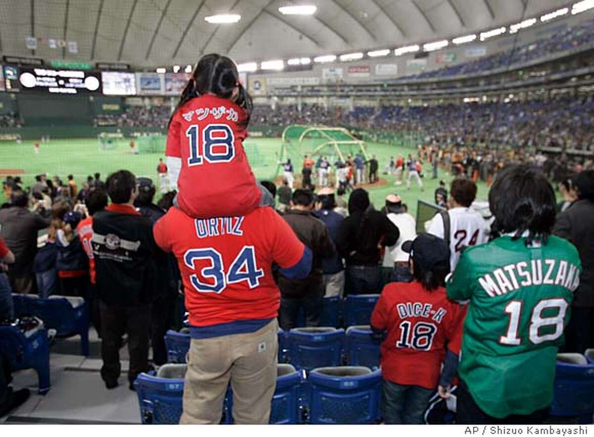 A girl wearing a Boston Red Sox pitcher Daisuke Matsuzaka T-shirt watches his team's practice session from the shoulders of an adult before the Major League Baseball regular season opener between the Red Sox and the Oakland Athletics at Tokyo Dome in Tokyo, Tuesday, March 25, 2008. (AP Photo/Shizuo Kambayashi)