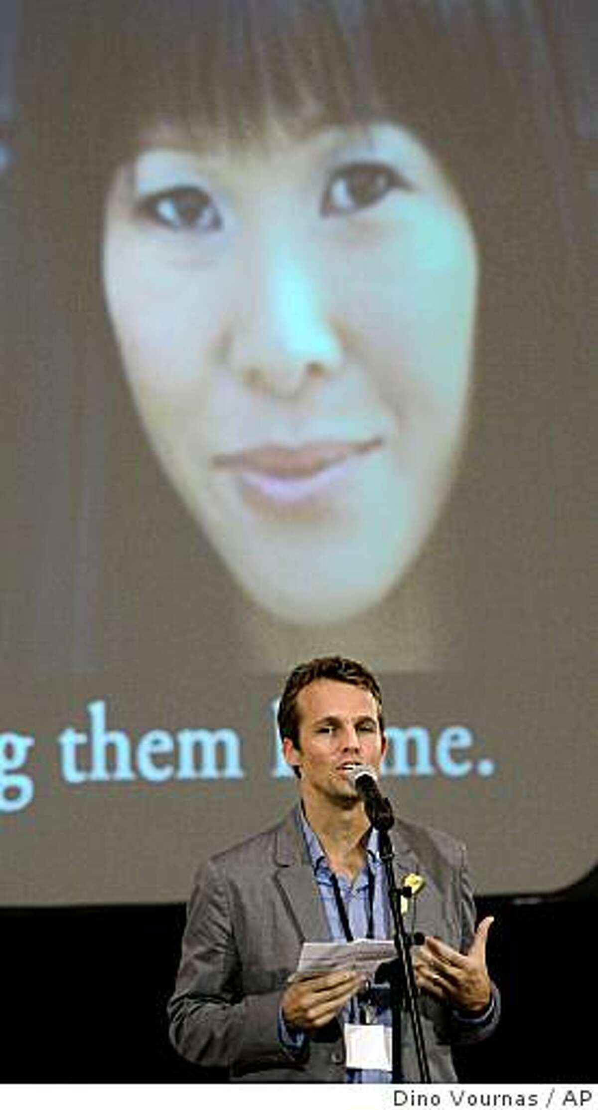 Iain Clayton, husband of Laura Ling (on screen), speaks to the crowd at the Academy of Art University during a vigil for the two journalists held by North Korea, Wednesday, June 24, 2009 in San Francisco. (AP Photo/Dino Vournas)