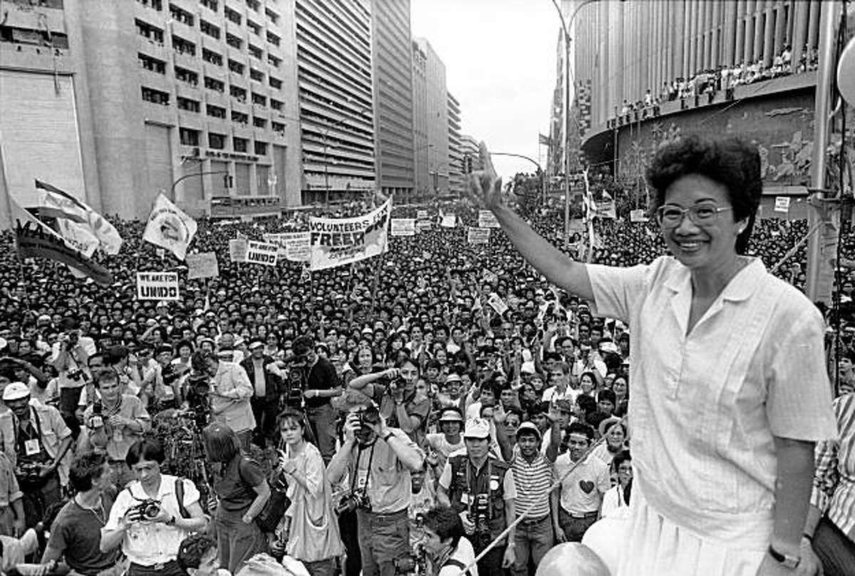 FILE - In this Jan. 27, 1986 file picture, opposition presidential candidate Corazon Aquino waves from the podium as thousands of supporters cheer during a campaign rally in downtown Manila. Aquino, who swept away a dictator and then sustained democracy by fighting off seven coup attempts in six years, died Friday, July 31, 2009. She was 76. (AP Photo/Val Rodriguez)