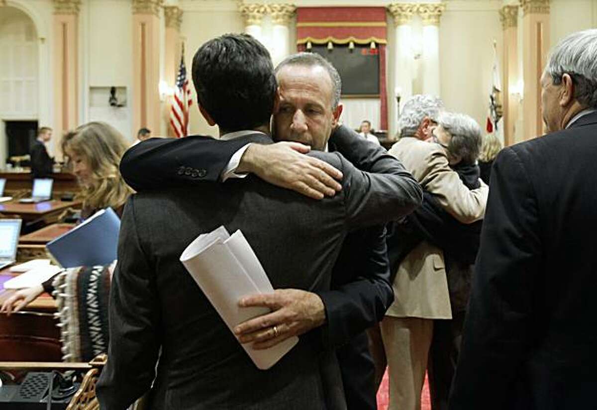 State Senate President Pro Tem Darrell Steinberg, D-Sacramento, center right, gets a hug from Sen. Mark Leno, D-San Franciso, left, after the Senate approved a package of 31 bills to close California's $26 billion budget deficit, at the Capitol in Sacramento, Calif., Friday, July 24, 2009. (AP Photo/Rich Pedroncelli)