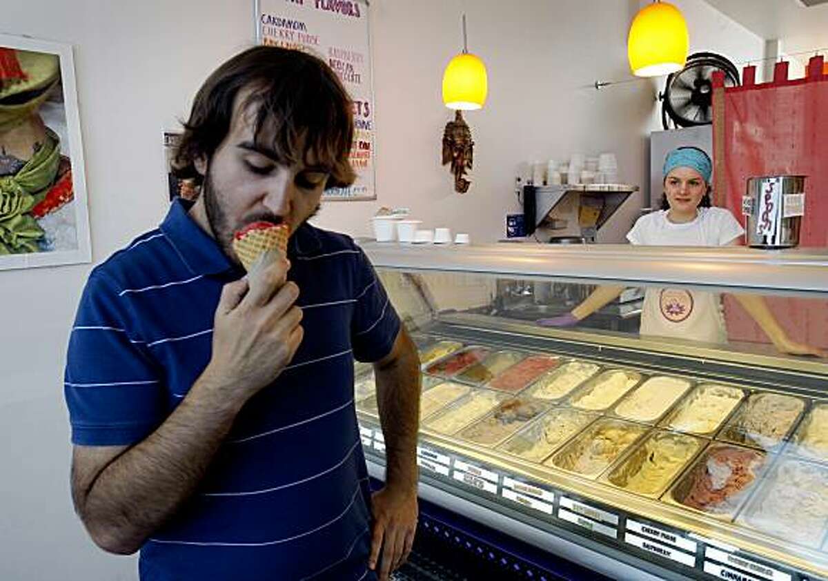 Tom Gartner bites into a cone of strawberry agave ice cream served by Rosa Page (right) at Tara's Organic Ice Cream shop in Berkeley, Calif., on Friday, July 17, 2009.