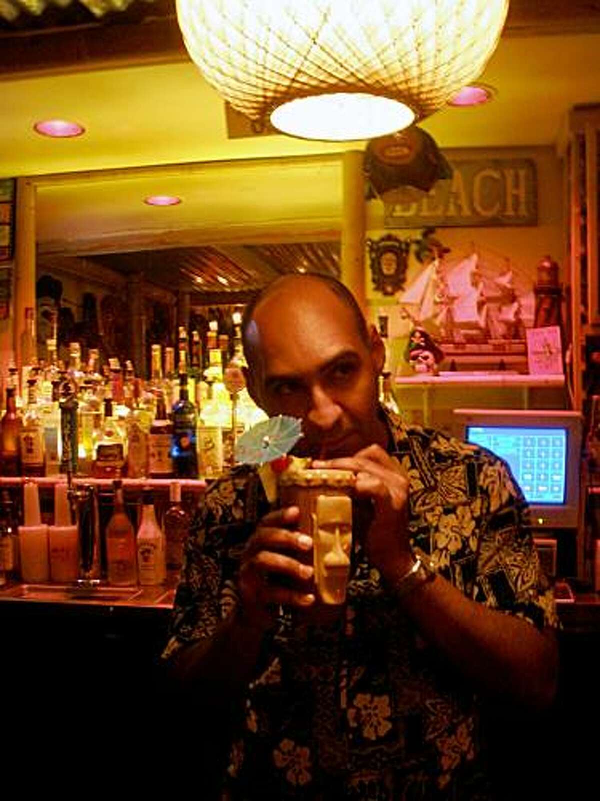 Tiki club owner Michael Thanos enjoys a drink at Conga Lounge in Oakland.