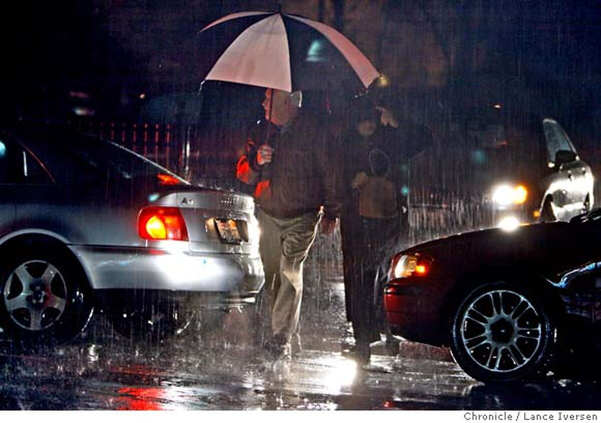 Pedestrians try to shield themselves as a heavy down pour falls on Bolinas Ave at Shady Ln. After heavy rain Friday night Police and fire units were forced to shut down most of San Anselmo business district as the Corda Madera creek reached the lip of it's banks. By Lance Iversen/The Chronicle MANDATORY CREDIT PHOTOG AND SAN FRANCISCO CHRONICLE/NO SALES MAGS OUT