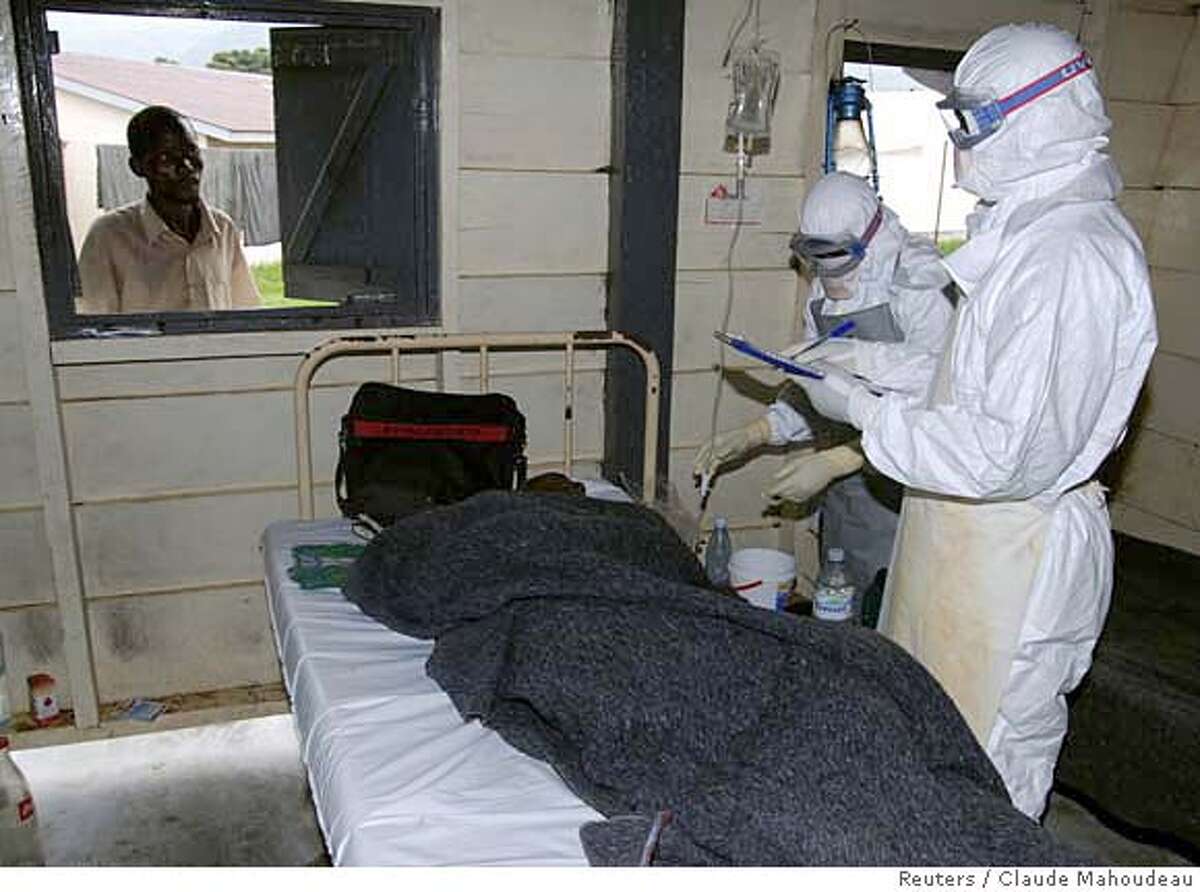 Medicins Sans Frontieres (MSF) staff attend an Ebola patient inside an isolation ward in Bundibugyo December 12, 2007 in this picture released by MSF on December 20, 2007. Uganda has had 124 cases of a new strain of Ebola fever that has killed 35 people. All the cases since the outbreak began in August have been in remote western Bundibugyo district, which borders Democratic Republic of the Congo (DRC), except for a doctor who died in the capital Kampala after returning from that area. Picture taken December 12, 2007. REUTERS/Claude Mahoudeau/MSF/Handout (UGANDA). EDITORIAL USE ONLY. NOT FOR SALE FOR MARKETING OR ADVERTISING CAMPAIGNS. EUO