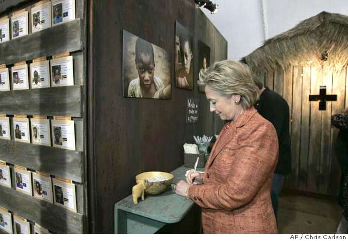 Democratic presidential hopeful, Sen. Hillary Rodham Clinton, D-N.Y., signs a note for the prayer wall in a AIDS exhibit at the Global Summit on AIDS & The Church at Saddleback Church in Lake Forest, Calif., Thursday, Nov. 29, 2007. (AP Photo/Chris Carlson)