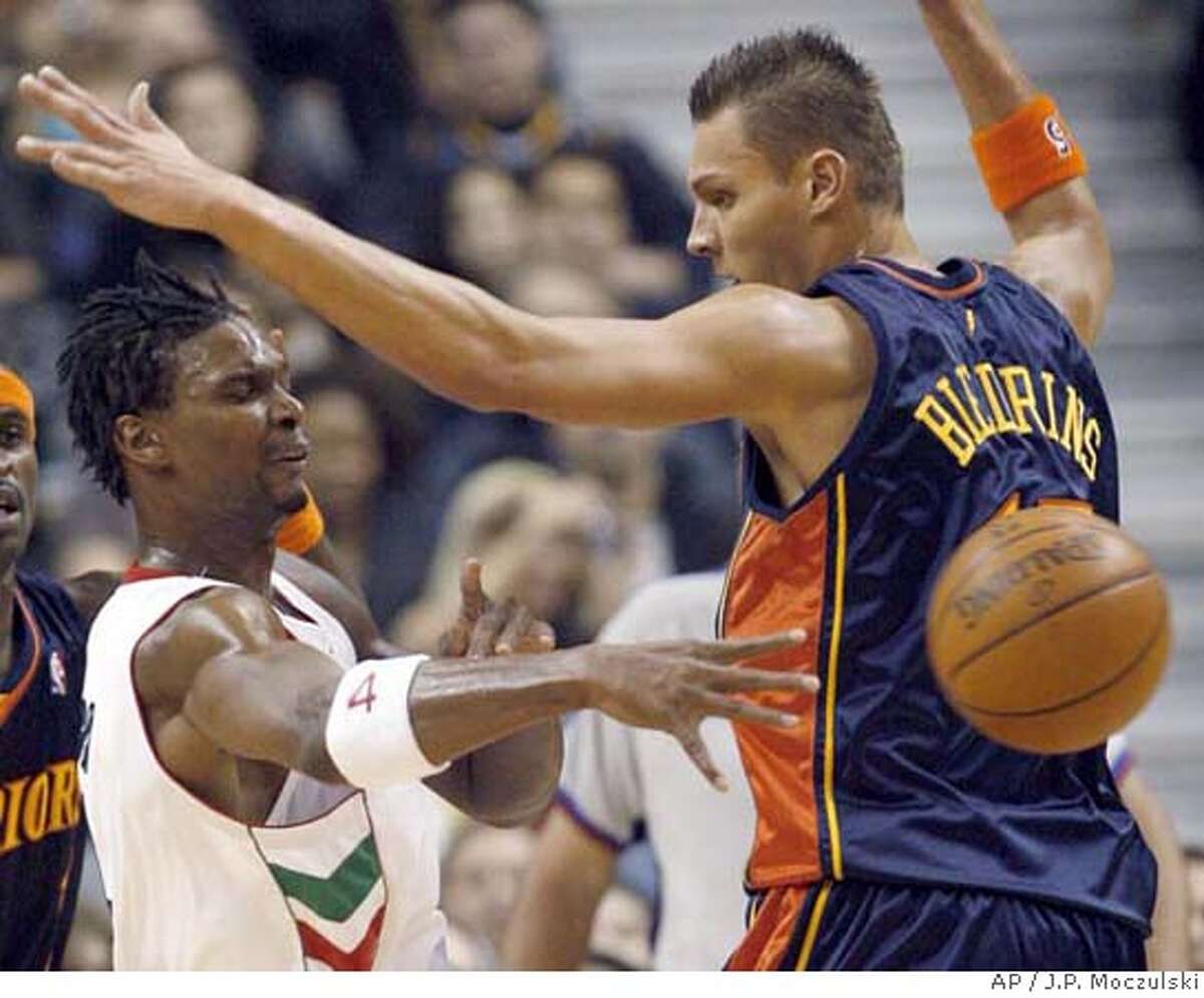 Toronto Raptors' Chris Bosh, left, passes off around Golden State Warriors' Andris Biedrins, right during the first half of their NBA basketball game in Toronto, Sunday, Nov. 18, 2007. (AP Photo/The Canadian Press,J.P. Moczulski) EFE OUT