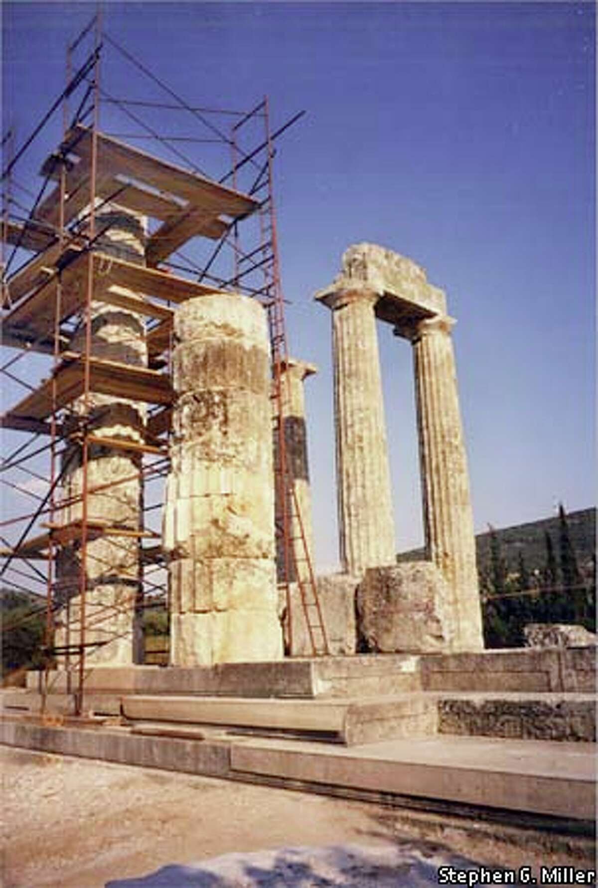 Stephen G. Miller and his archaeology crews are rebuilding one of the great limestone Doric columns that once encircled the temple of Zeus at Nemea. In front of the scaffolding stands the half-column that will be completed next summer. To the right are two of the three original columns that have stood since the time of the Nemean games. Photo courtesy of Stephen G. Miller
