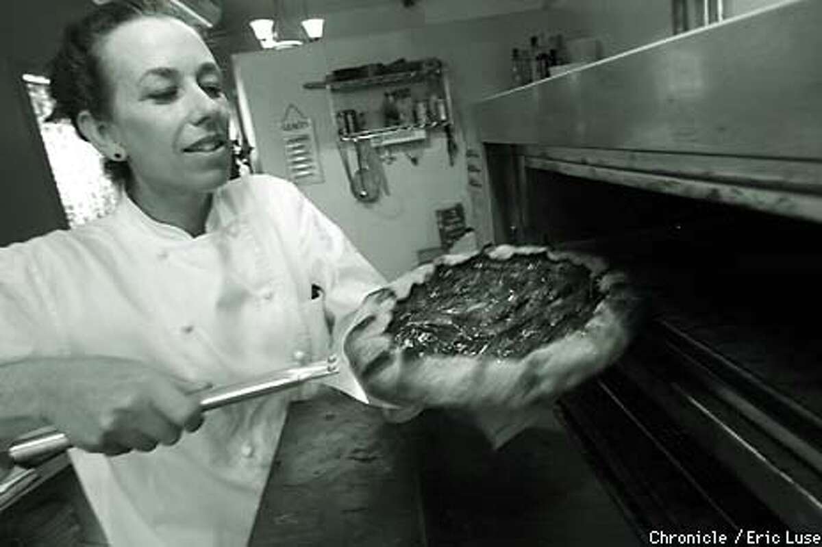 Mary Jo Thoresen carefully removes a fresh plum galette from the oven. Chronicle photo by Eric Luse