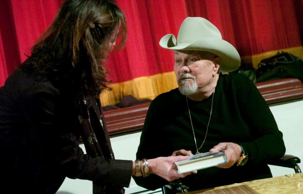 Tony Curtis hands an autographed copy of his book to Karen Eddowes, of Stamford, during a fundraising event at the Avon Theatre Film Center in Stamford, Conn. on Sunday, Nov. 11, 2009.