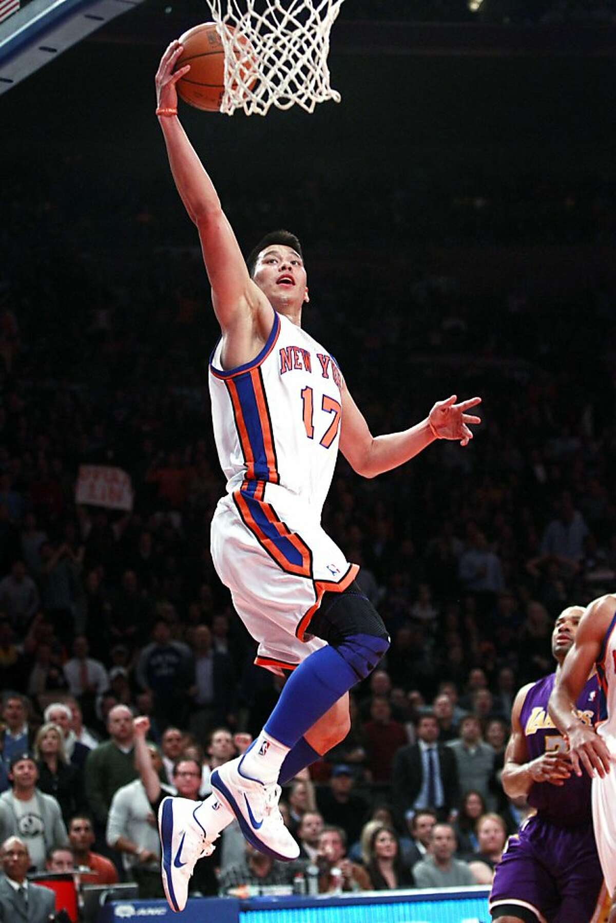 New York Knicks' Jeremy Lin (17) drives past Los Angeles Lakers' Derek Fisher during the first half of an NBA basketball game, Friday, Feb. 10, 2012, in New York. (AP Photo/Frank Franklin II)