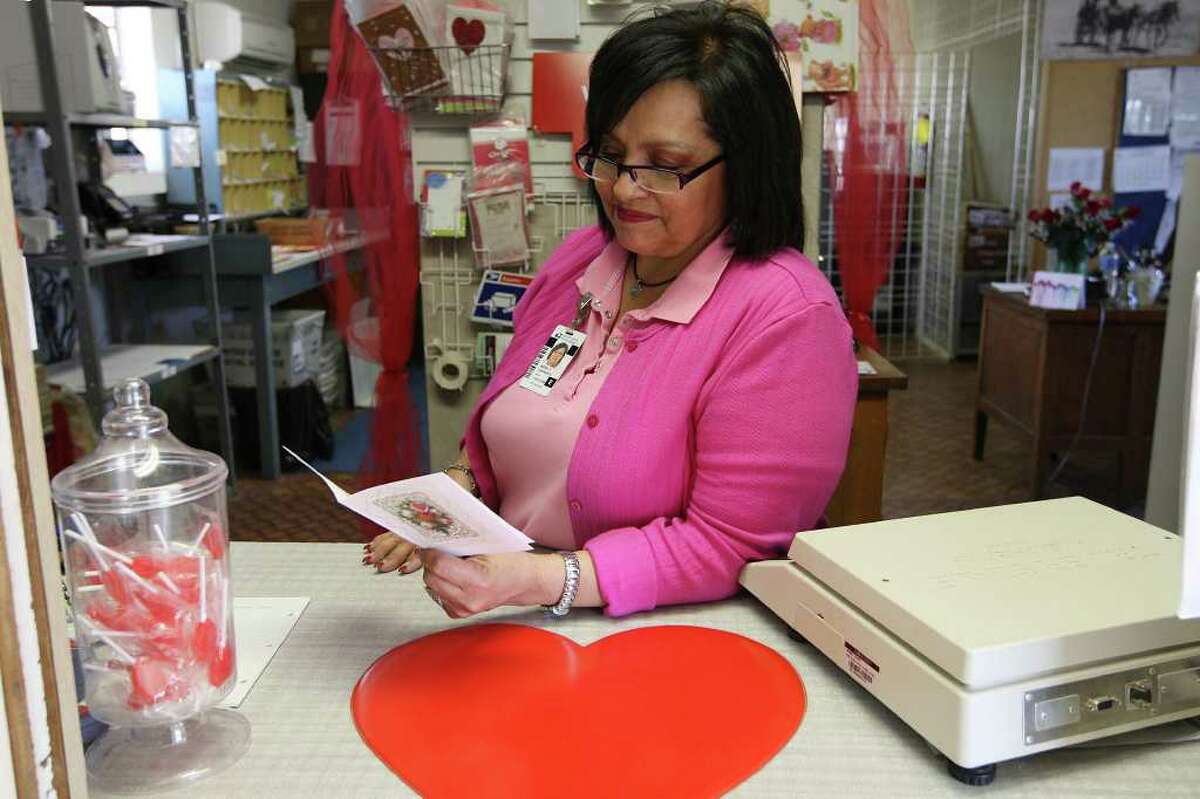 U.S. Postmaster Maria Carrasco reads a Thank You card sent to her at the Valentine, Texas post office, Tuesday, Feb. 7, 2012. The West Texas post office handles over 10 times more daily volume during the days leading up to Valentine's Day on February 14th. It's also on the list for possible closure by the U.S. Postal Service. Carrasco figured that she has hand-stamped Valentine cards destined for cities all over the world.