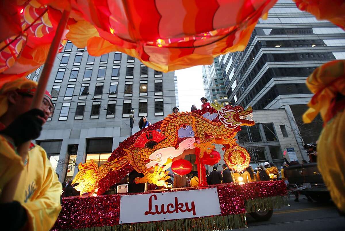 Members of the Community Youth Center of San Francisco, foreground, pass by the Lucky float with their dragon at the Chinese New Year parade in San Francisco, Calif., Saturday, February 11, 2012.