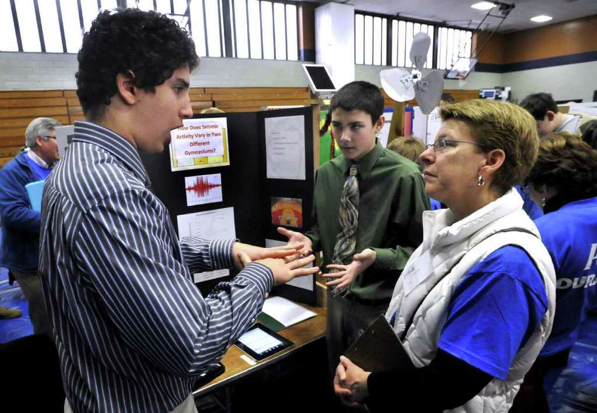 Bethel Middle School eigth graders Abraham DeFeo, left, and Joe Moutimer, explain their expierment to Judge Patty Heyl, during the Science Horizons regional science fair in Danbury saturday, Feb. 11, 2012.