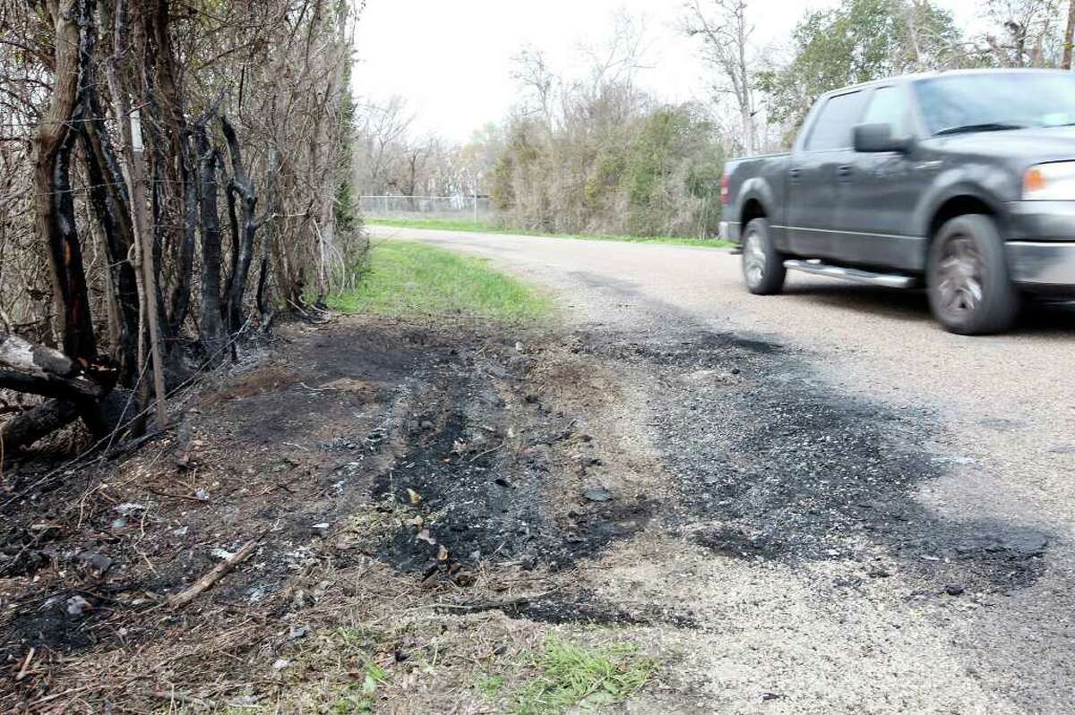 A truck passes the charred area on the shoulder of Eastland Lake Road, Sunday Feb. 12, 2012 in Waco, TX., where Baylor University freshman William Patterson was found dead in his burning car early Thursday.