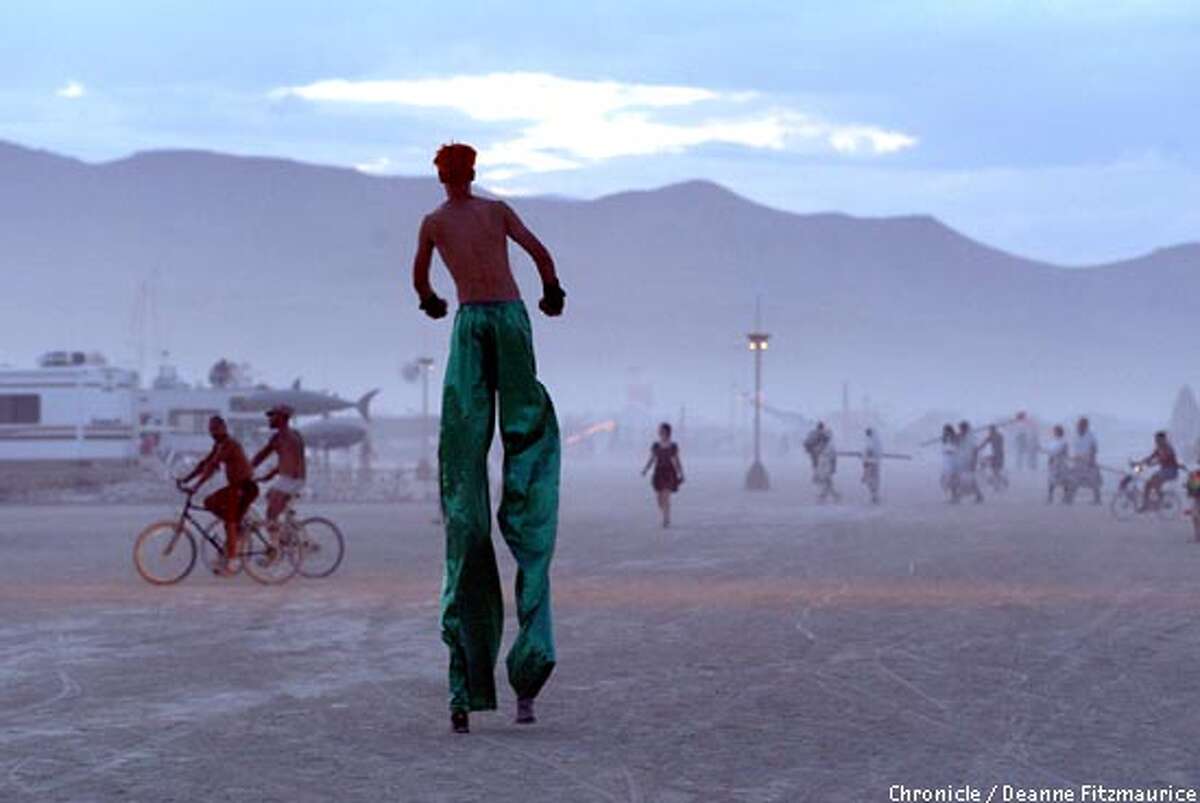 A man on stilts walks across the playa at Burning Man in the Black Rock Desert in Nevada. CHRONICLE PHOTO BY DEANNE FITZMAURICE