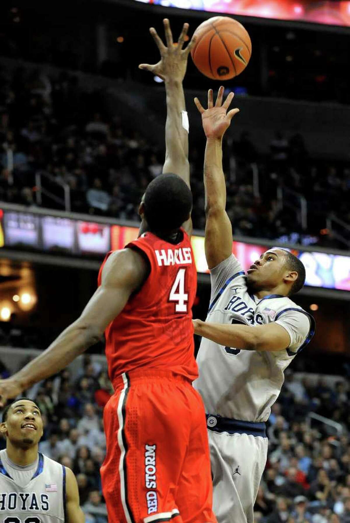Georgetown's Markel Starks, right, goes up for the shot and two points against the defense of St. John's Moe Harkless (4) during second half of their NCAA college basketball game on Sunday, Feb. 12, 2012, in Washington. Georgetown defeated St. John's 71-61. (AP Photo/Richard Lipski)