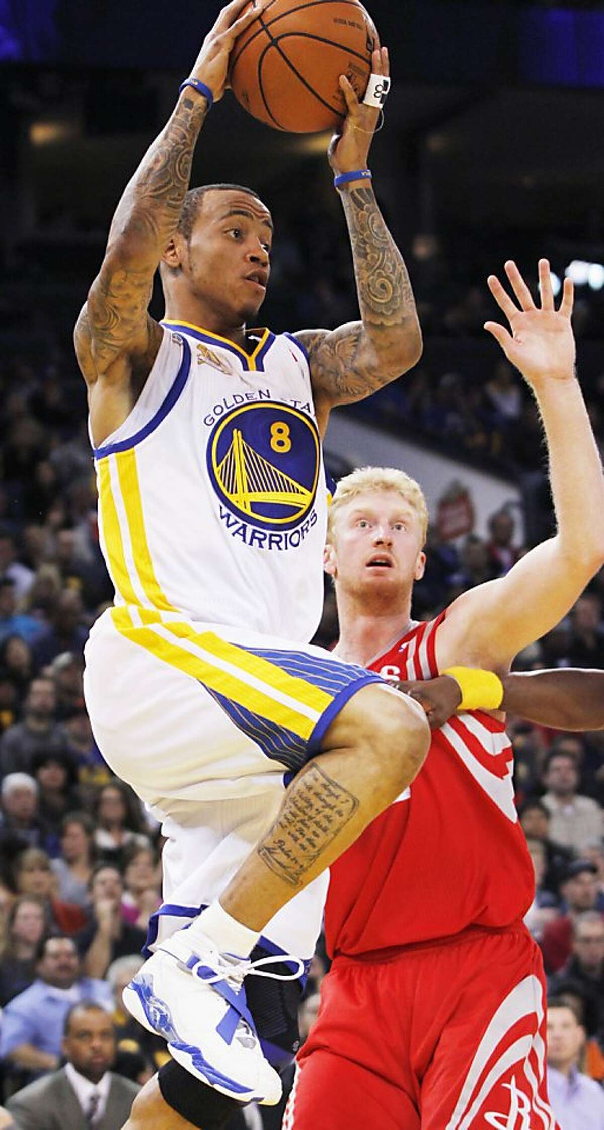 Golden State Warriors' Monta Ellis (8) heads past Houston Rockets' Chase Budinger, during the first half of an NBA basketball game, Sunday, Feb. 12, 2012, in Oakland, Calif. (AP Photo/George Nikitin)