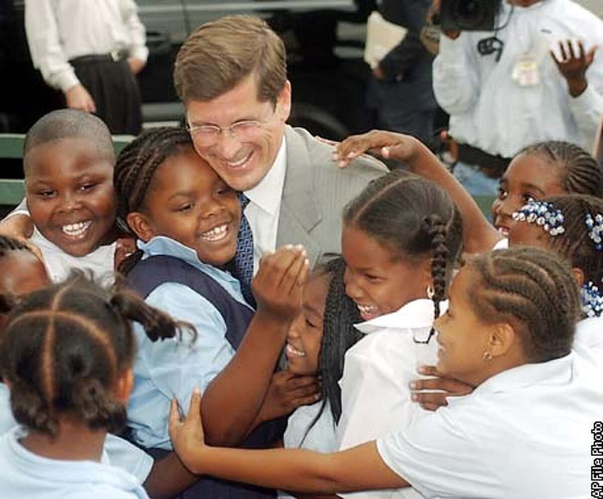 ** CORRECTS DATE TO SEPT. 5, NOT AUG. 5 ** Republican gubernatorial candidate Bill Simon, in suit, is greeted by children at the Watts Learning Center in Los Angeles, Thursday, Sept. 5, 2002. Simon visited the Los Angeles Unified charter school to discuss education policy. He is to face California Gov. Gray Davis, a Democrat, in the November general election. (AP Photo/John Hayes)