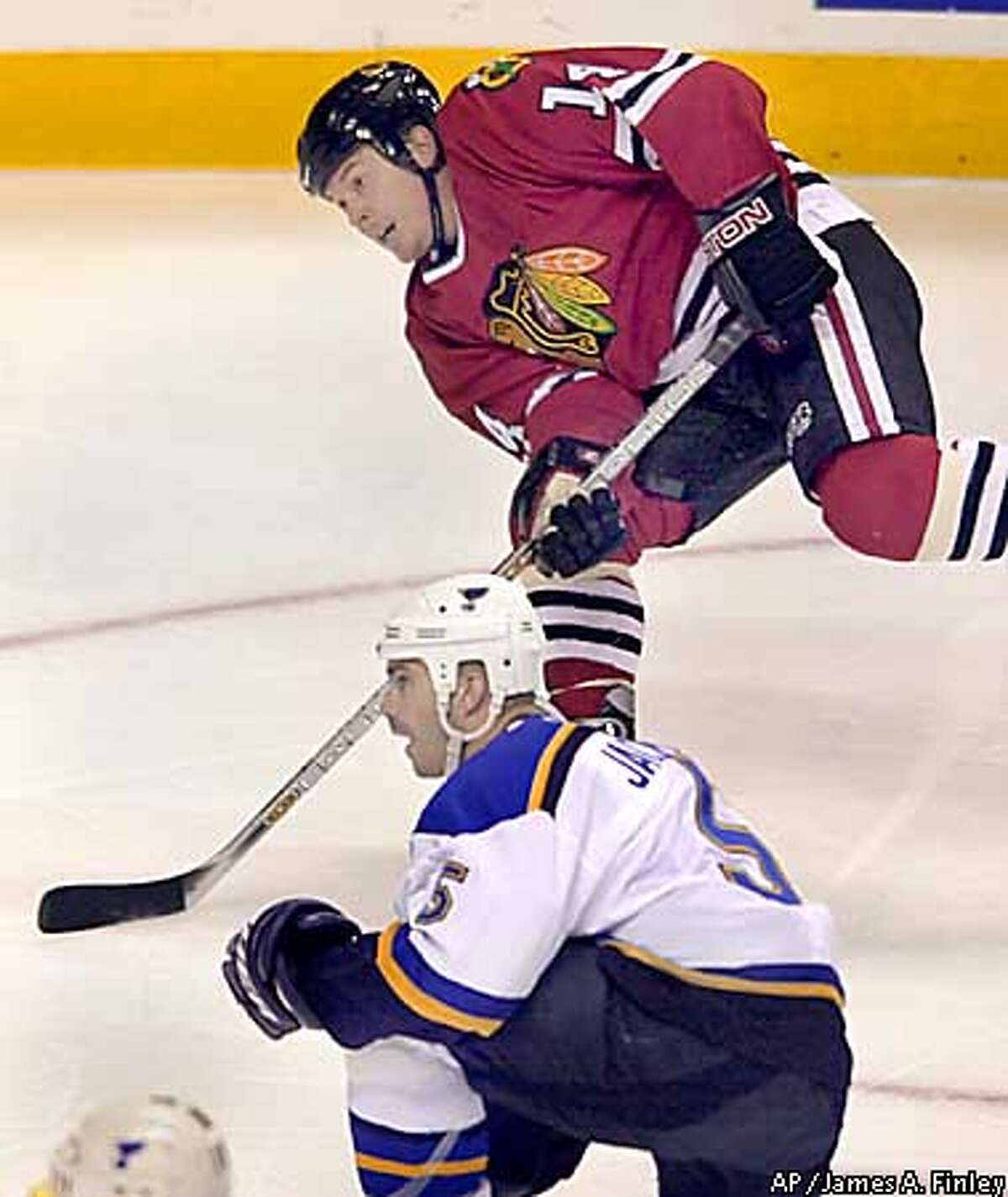 Chicago Blackhawks Theo Fleury (14) takes a shot on goal during the first period against the St. Louis Blues while Barret Jackson (5) looks on in their NHL preseason game at the Savvis Center in St. Louis Friday, Oct. 4, 2002. (AP Photo/James A. Finley)